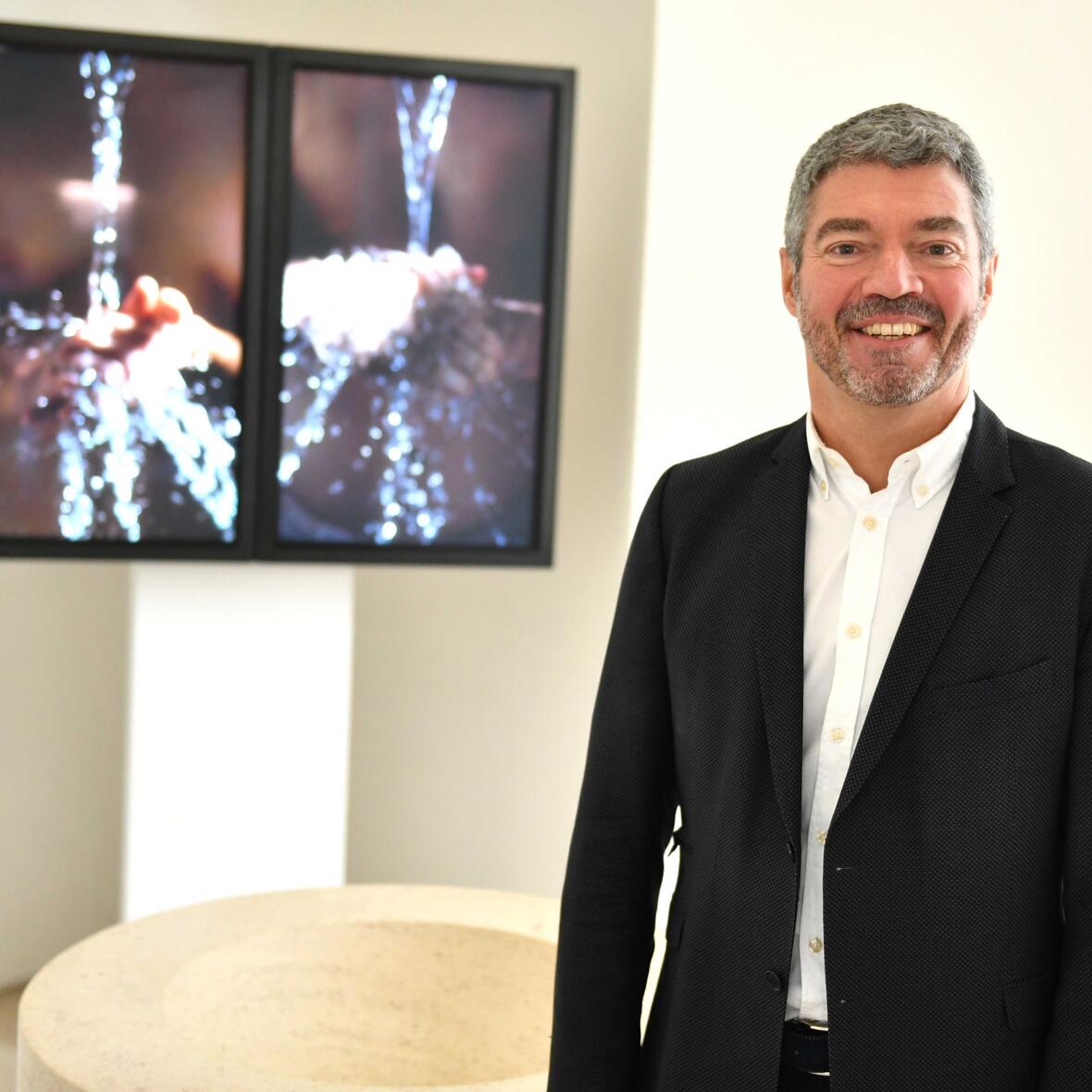 Dekan Helmut Haug in der Taufkapelle der Moritzkirche, im Hintergrund eine von vier bis September ausgestellten Videoinstallationen des Künstlers Bill Viola. (Foto: Nicolas Schnall / pba)