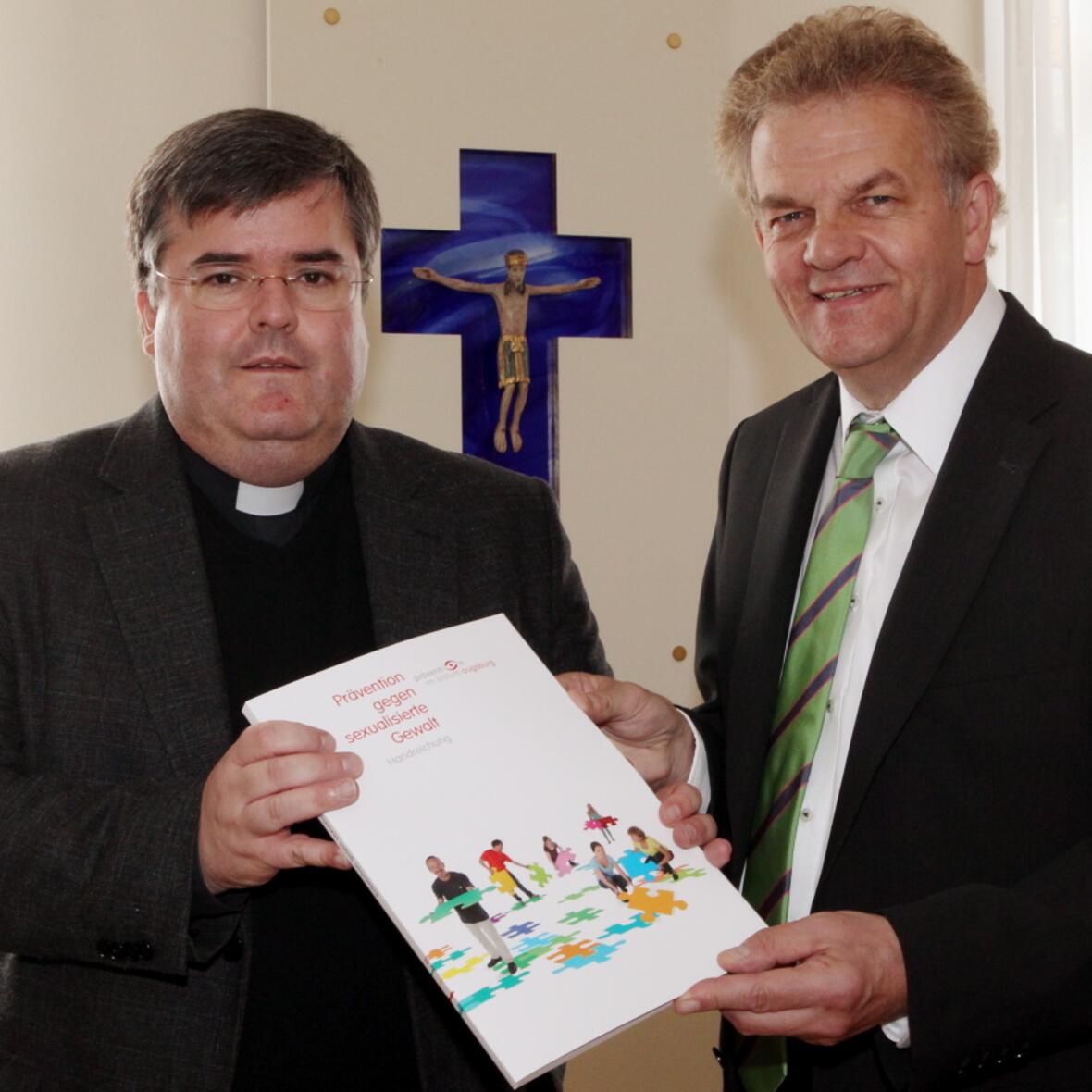 Soeben hat Generalvikar Harald Heinrich das erste Exemplar der Handreichung an Pastoralreferent Bernhard Scholz überreicht. Er leitet die diözesane Koordinationsstelle zur Prävention gegen sexualisierte Gewalt. (Foto: Annette Zoepf/pba)
