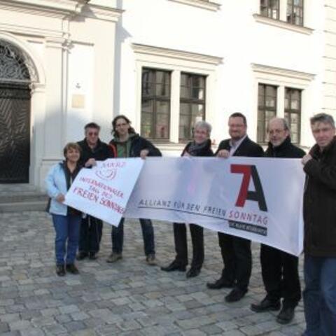 V.l. Neyla Sevinchan (Afa Augsburg), Eugen Hänel (kda Augsburg), Bernhard Stappel (Kath. Betriebsseelsorge Augsburg), Peter Ziegler (KAB Augsburg), Stefan Blumtritt (Evang. Dekanat Augsburg), Erwin Helmer und Lothar Roser (beide KAB Augsburg) bei der Plakatenthüllung im Augsburger Annahof.