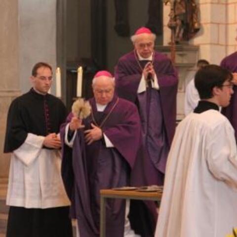 Bischof Dr. Konrad Zdarsa segnet die Asche mit Weihwasser.