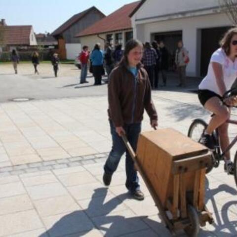 Mädchen beim Rätschen mit großer "Schubkarrenrätsche"