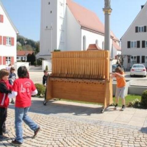 Zwei Buben betätigen die "größte Rätsche der Welt".