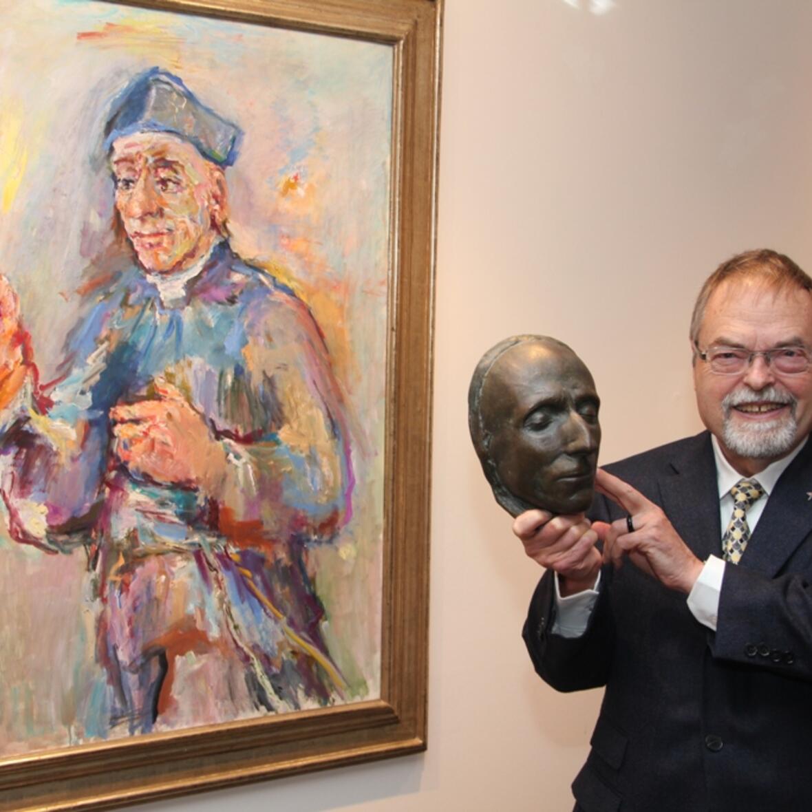 P. Peter Hinsen SAC hält die Totenmaske von Vinzenz Pallotti, die der Bildhauer Max Faller angefertigt hat, vor dem Bild Kokoschkas