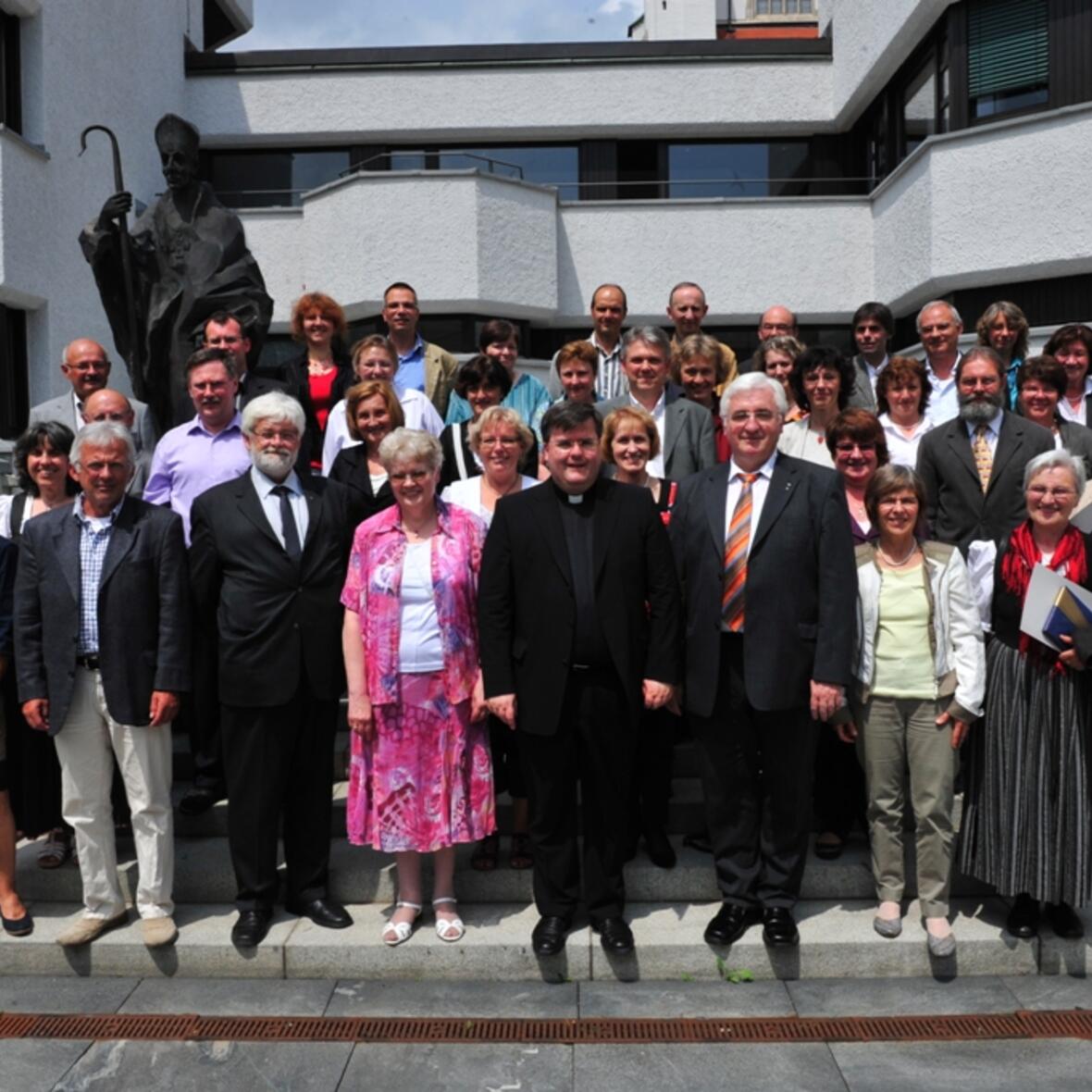 Gruppenbild an der Bronzeplastik des Hl. Ulrich: 57 weltliche Mitarbeiter der Diözese Augsburg konnten heute am Fest des Hl. Ulrich ihr Dienstjubiläum feiern