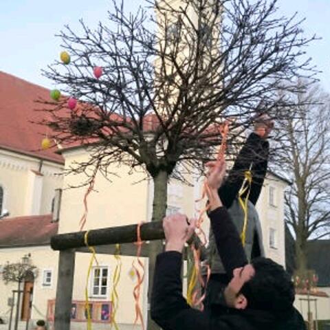 Gemeinschaftsstiftende Aktion vor der Pfarrkirche Mariä Himmelfahrt: Ali und Mohamad, beide Flüchtlinge aus Syrien, helfen in Türkheim beim traditionellen Schmücken der Osterbäume. (Foto: Helferkreis Türkheim/Rummel)
