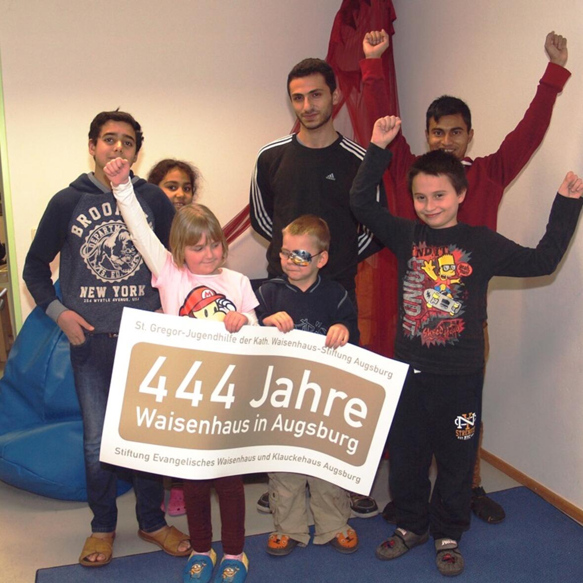 Kinder und Jugendliche präsentieren das Logo, das die St. Gregor Kinder-, Jugend- und Familienhilfe gGmbH der Katholischen Waisenhaus-Stiftung Augsburg und das Evangelische Kinder- und Jugendhilfezentrum der Stiftung Evangelisches Waisenhaus und Klauckehaus Augsburg durch das ungewöhnliche Jubiläumsjahr begleiten wird. (Foto: St. Gregor-Jugendhilfe/Daniela Lutz)