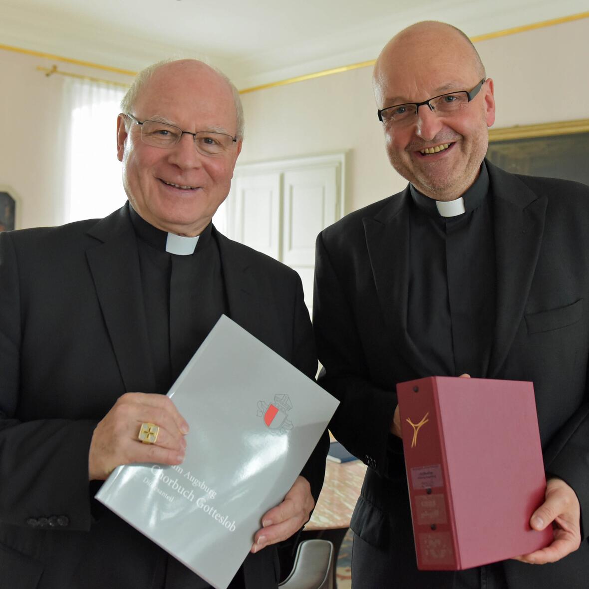 Pater Stefan Kling (rechts) überreicht Bischof Konrad die beiden Neuerscheinungen. (Fotos: pba/Romana Kröling)
