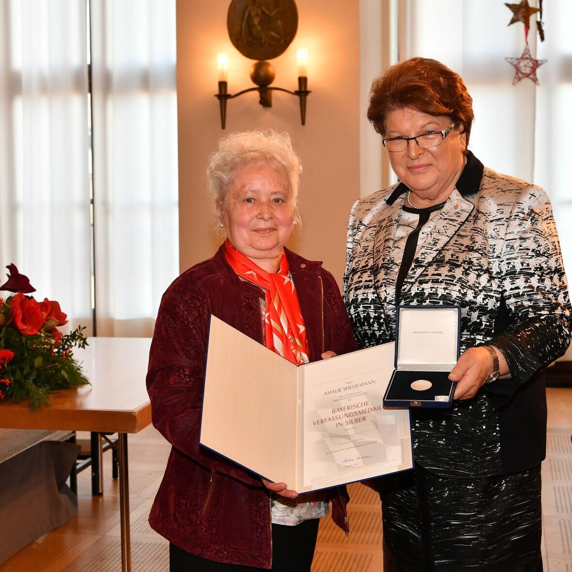 Amalie Wiedemann (links) von den Maltesern Augsburg erhält von Landtagspräsidentin Barbara Stamm die silberne Verfassungsmedaille. (Bildrechte: Bildarchiv Bayerischer Landtag/Foto: Rolf Poss)