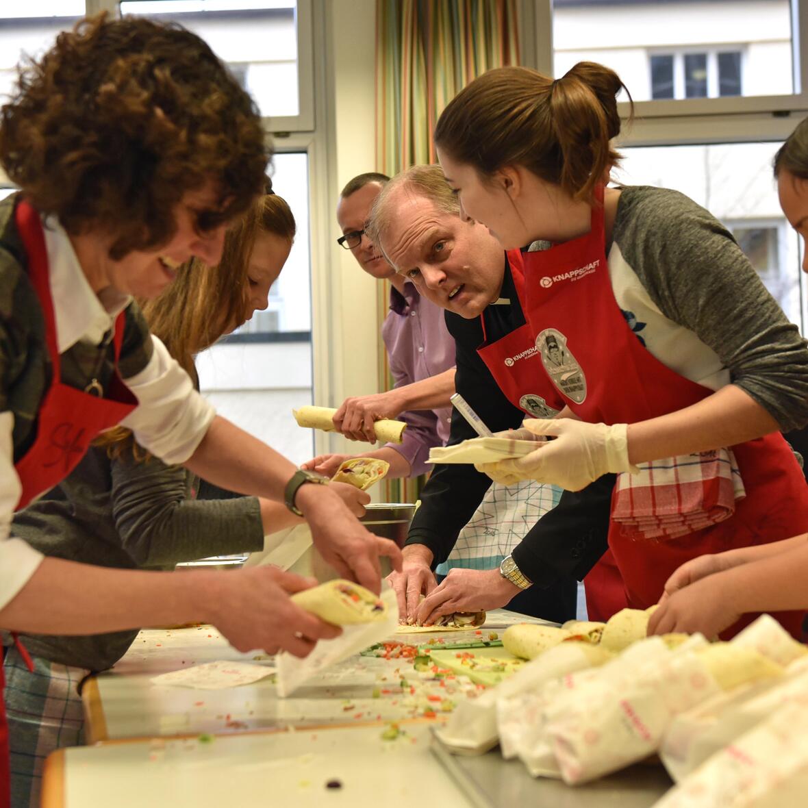 Weihbischof Florian Wörner bereitete heute mit Schülerinnen und Schülern sowie mit der Schulleitung der Augsburger Maria-Stern-Schulen Wraps zu. (Fotos: Romana Kröling / pba)