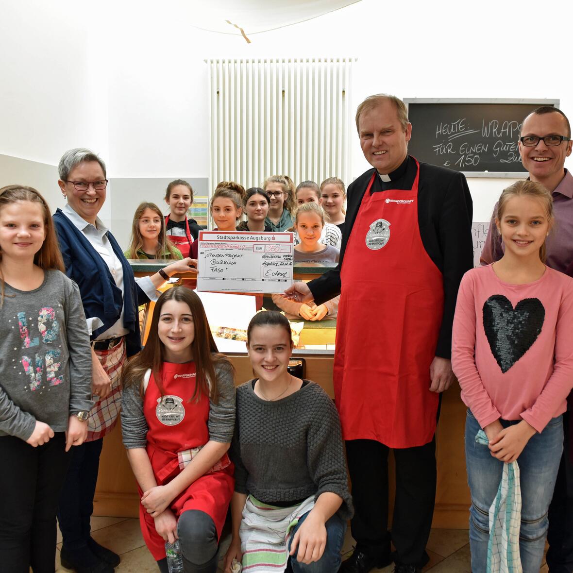 Weihbischof Florian Wörner erhielt nach dem Pausenverkauf einen Spendenscheck für das Hilfsprojekt.