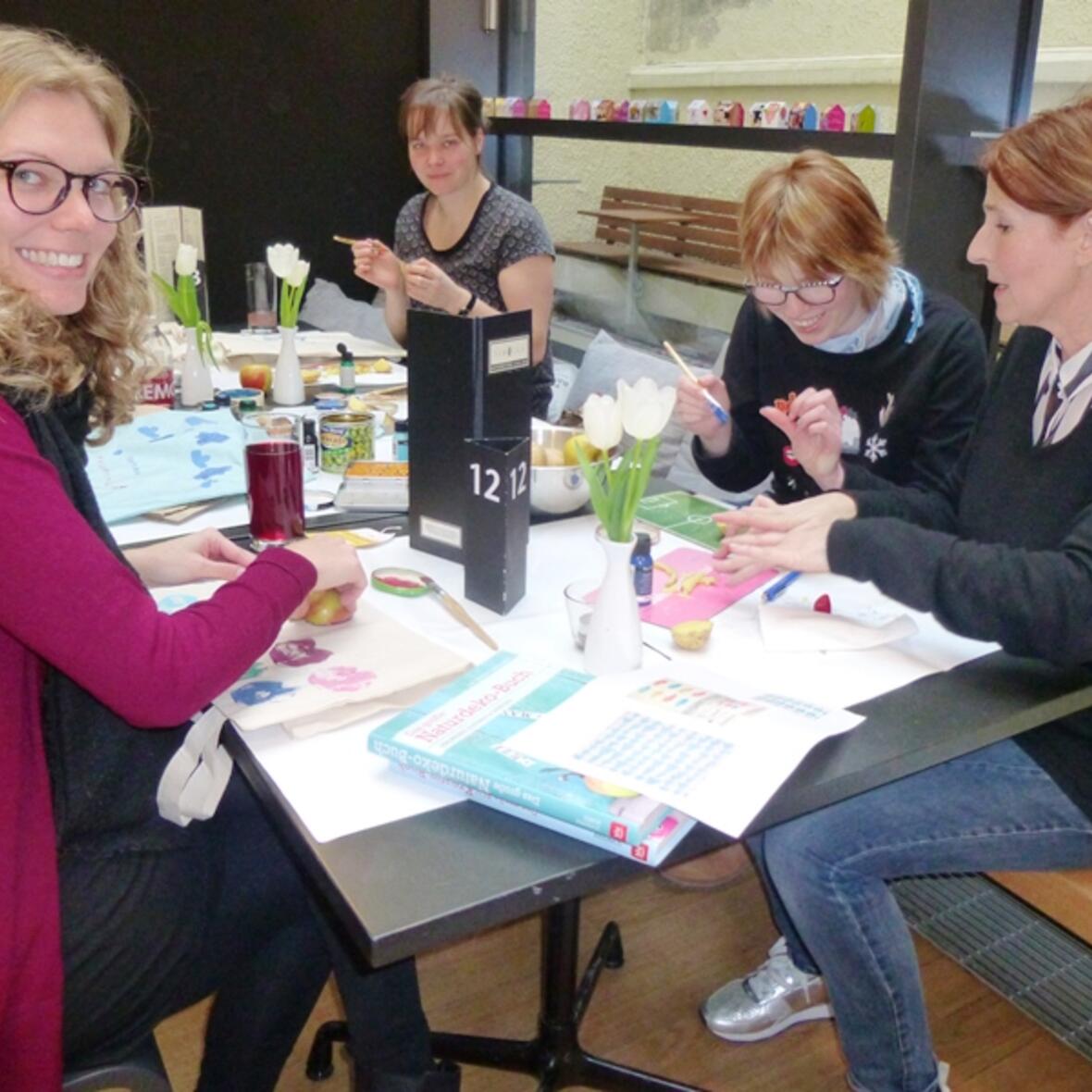 Die Designerin Eva Neumann (recht) und Tanja Blum (links) haben zu „Kunst & Kuchen“ ins Café Samocca geladen. (Foto: Caritas Augsburg/Gerlinde Knoller)