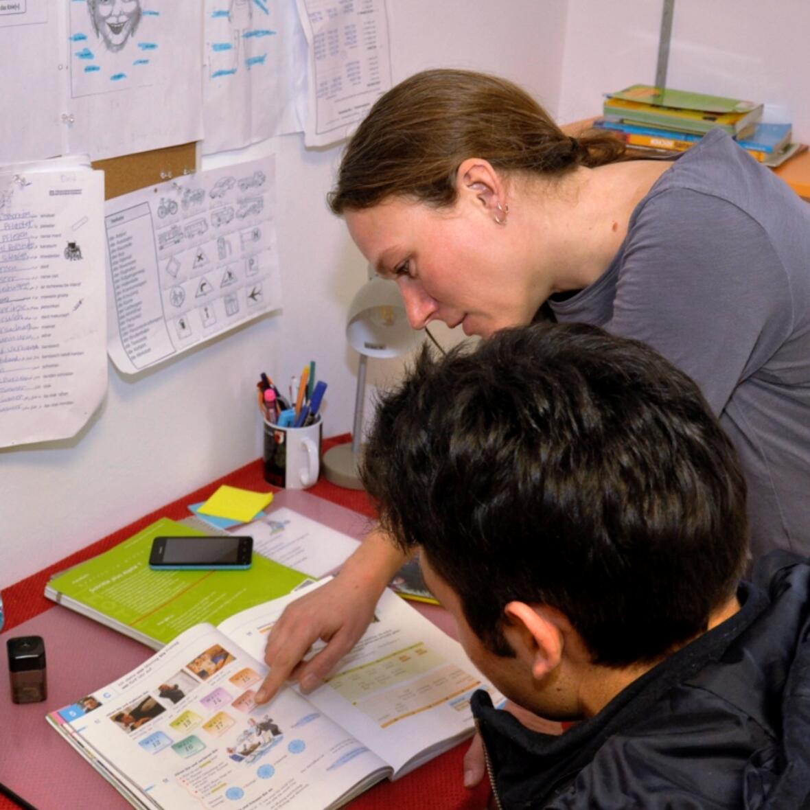 Carolin Faßnacht hilft Amir beim Deutschlernen. Im Augsburger Förderwerk St. Elisabeth werden in einer Wohngruppe zwölf junge Flüchtlinge betreut. (Fotos: KJF/Ruf)