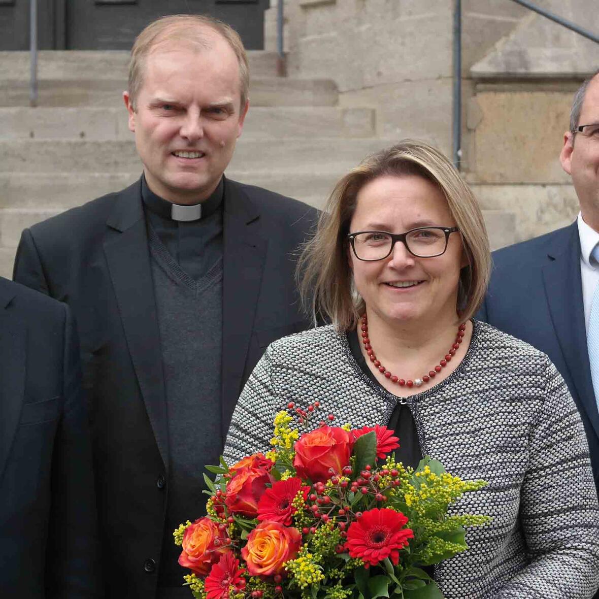 Blumen für Preisträgerin Christine Frank. Mit ihr freuen sich (von links) Ulrich Haaf, Direktor des Schulwerks der Diözese Augsburg, Weihbischof Florian Wörner und Peter Kosak. Er wird ab Januar die Leitung des Schulwerks übernehmen. (Foto: Karl-Georg Michel/pba)