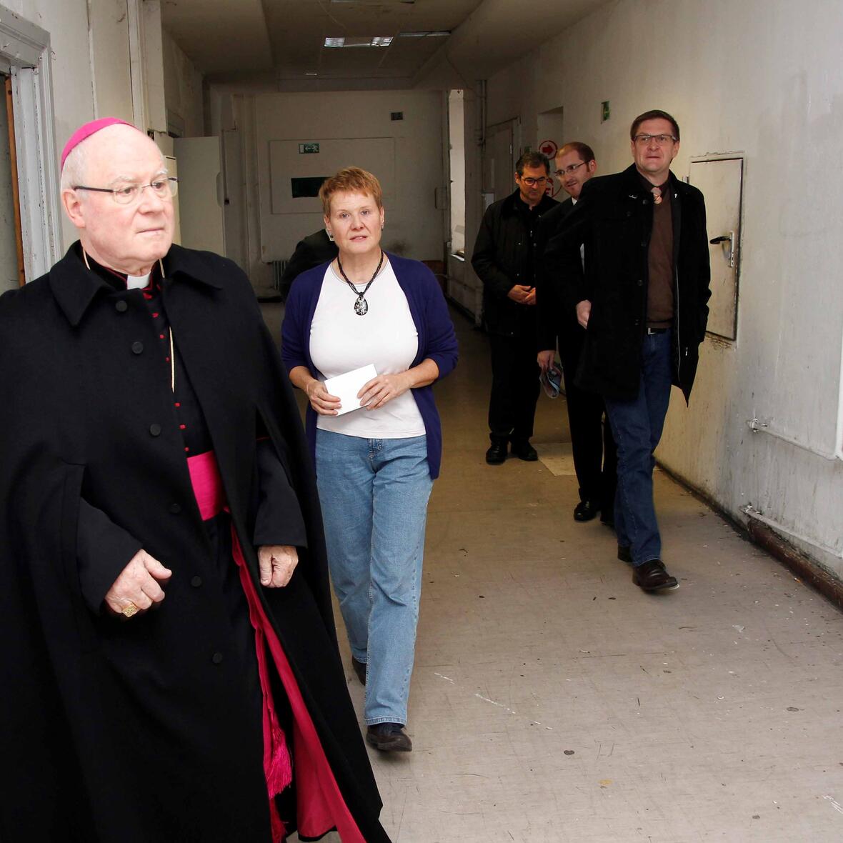 Das Entsetzen über die Zustände in der Calmbergstraße ist dem Gesicht des Bischofs abzulesen. Beim Rundgang durch die Gemeinschaftsunterkunft wird er begleitet von Susanne Thoma vom Ehrenamtlichen-Projekt "Voll dabei", Diözesan-Caritasdirektor Domkapitular Dr. Andreas Magg und dem Flüchtlingsbeauftragten der Diözese, Diakon Ralf Eger (r.). (Foto: Caritas/Bernhard Gattner)