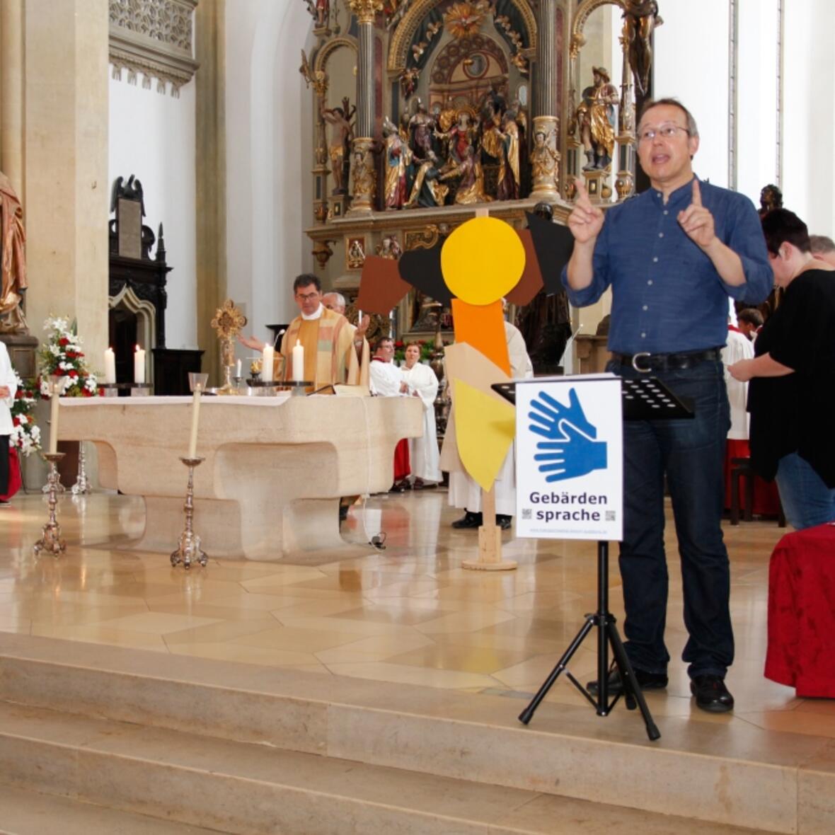 Michael Geisberger von der Hörgeschädigtenseelsorge der Diözese Augsburg übersetzte jedes Wort im Gottesdienst simultan in die Gebärdensprache. (Foto: Caritas/Bernhard Gattner)