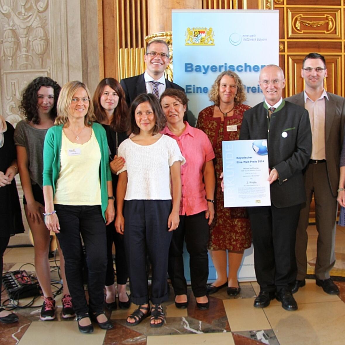 Regierungspräsident Scheufele (mit Urkunde) freut sich mit Mitarbeitern der aktion hoffnung über den 2. Preis. (Foto: Eine Welt Netzwerk Bayern e.V. / I. Wittenzellner)