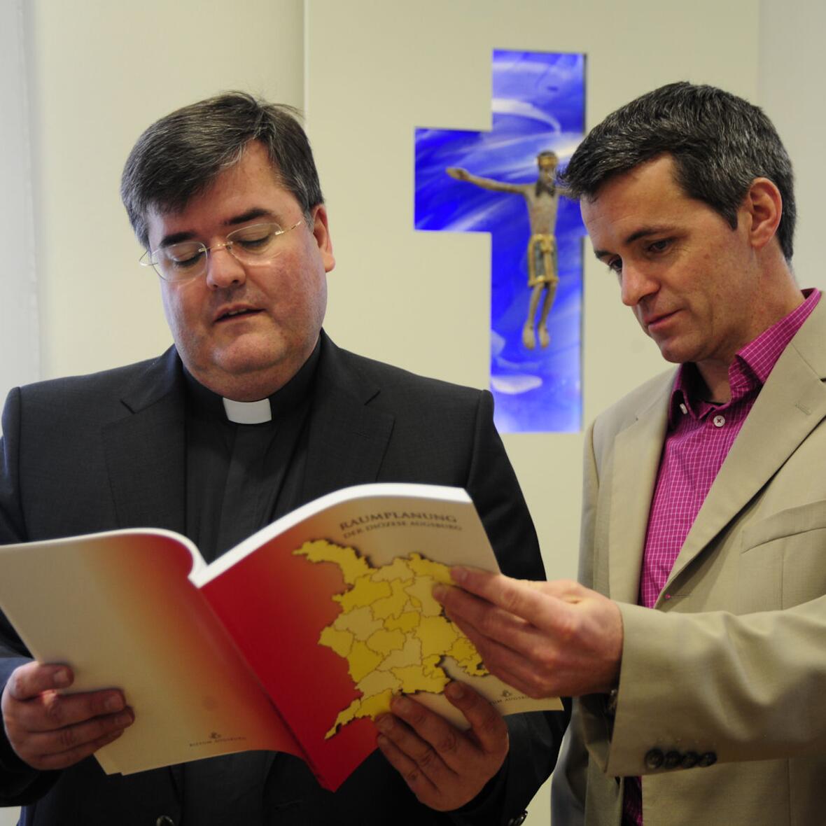 Generalvikar Harald Heinrich und sein persönlicher Referent Karl Wolf werfen einen ersten Blick in die neue Publikation.