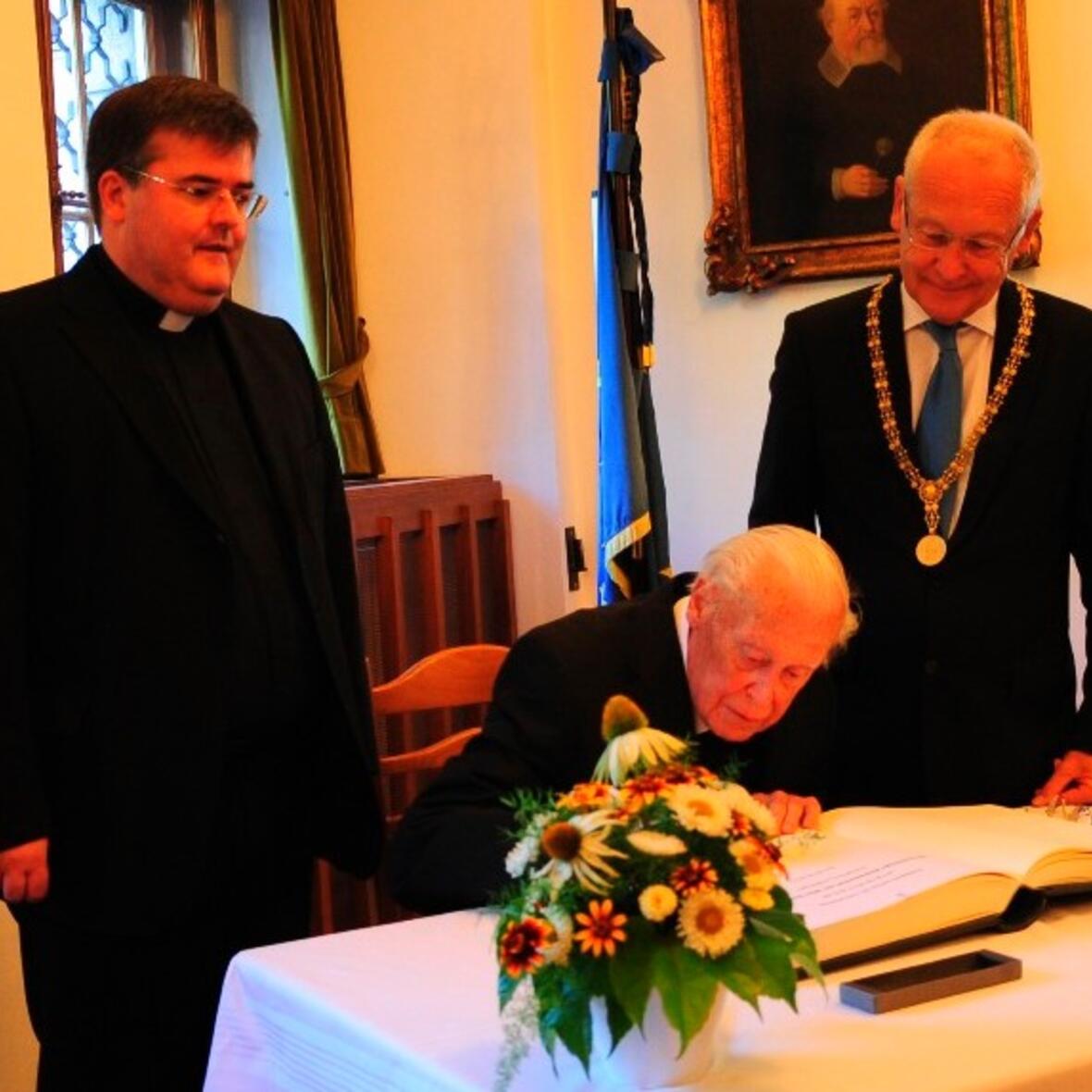 Generalvikar Harald Heinrich, Weihbischof em. Max Ziegelbauer und Oberbürgermeister Dr. Ivo Holzinger beim Eintrag ins Goldene Buch der Stadt.