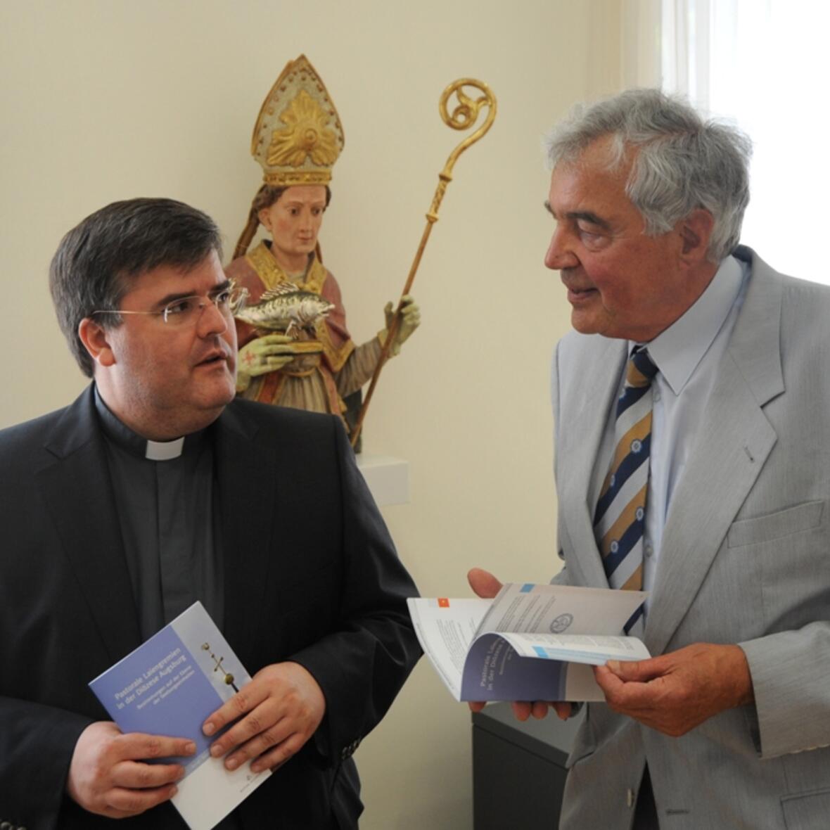 Generalvikar Harald Heinrich und Diözesanratsvorsitzender Helmut Mangold mit den ersten Exemplaren der neuen Satzungen. Foto: pba / Nicolas Schnall