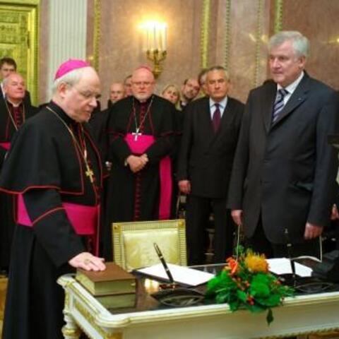 Bischof Dr. Konrad Zdarsa (links vorne) sprach mit der rechten Hand auf der Bibel die Eidesformel. 2. R. v.l. Weihbischof Dr. Dr. Anton Losinger (Augsburg), Erzbischof Reinhard Marx (München), Staatsminister für Unterricht und Kultus Ludwig Spaenle und Ministerpräsident Horst Seehofer. Bild: Fuchs