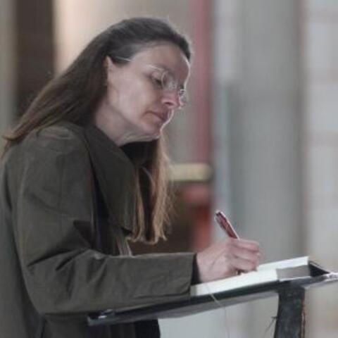 Eine Gläubige trägt sich in das Glückwunschbuch für Bischof Zdarsa ein.