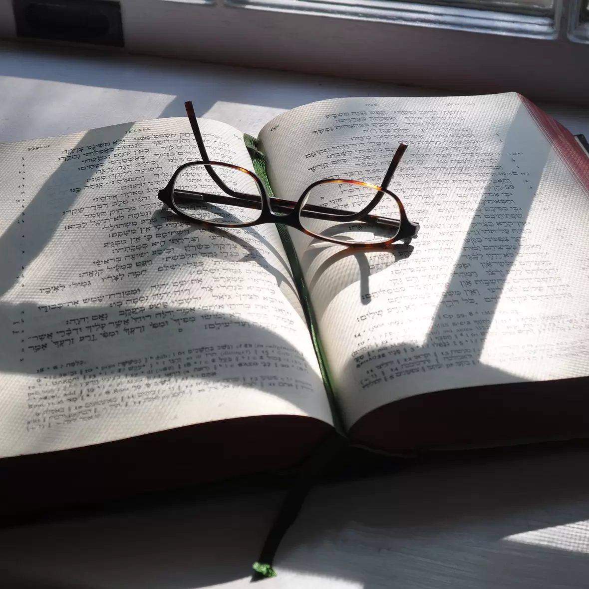 Aufgeschlagene Bibel, Brille liegt darauf