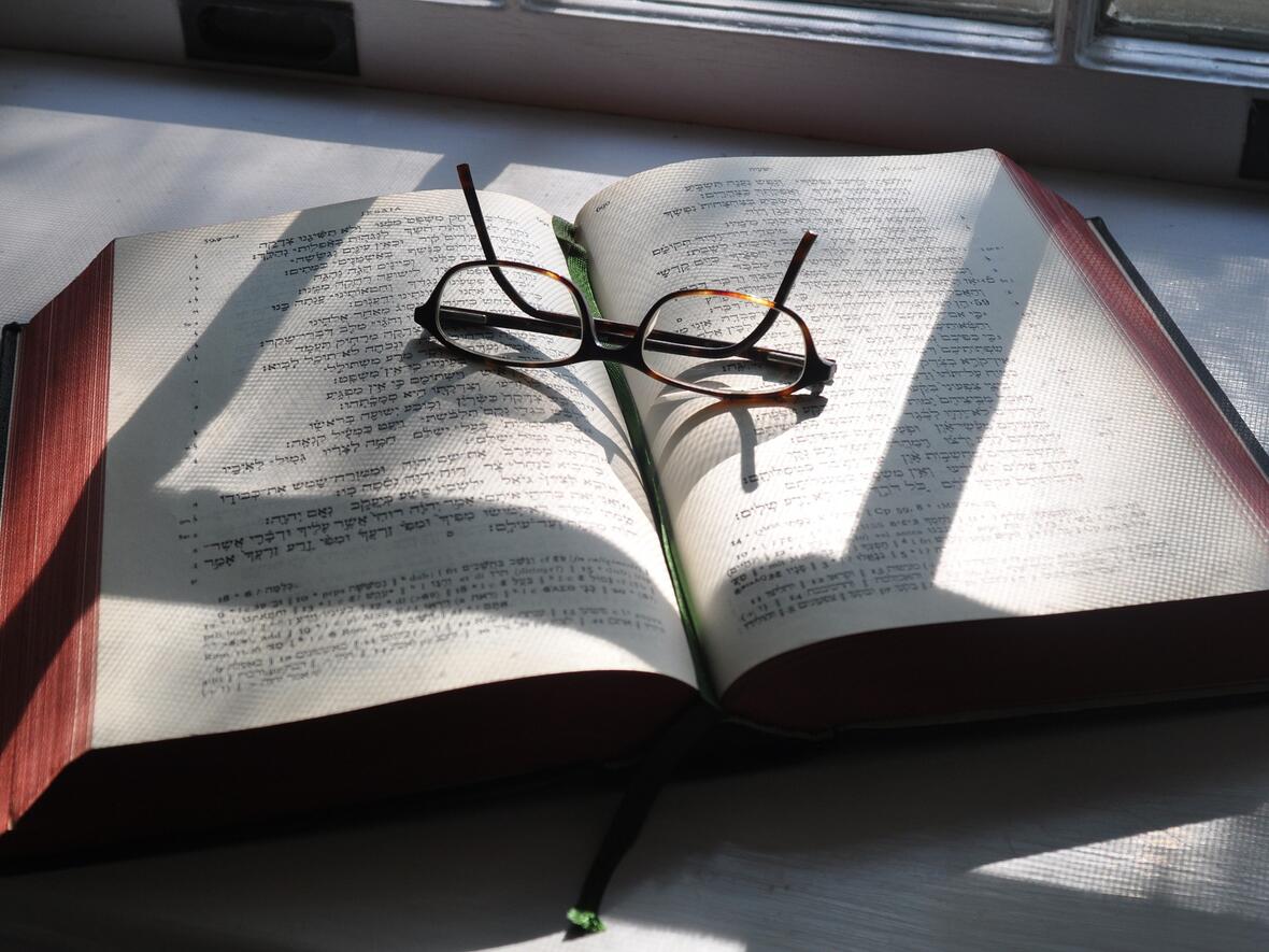 Aufgeschlagene Bibel, Brille liegt darauf