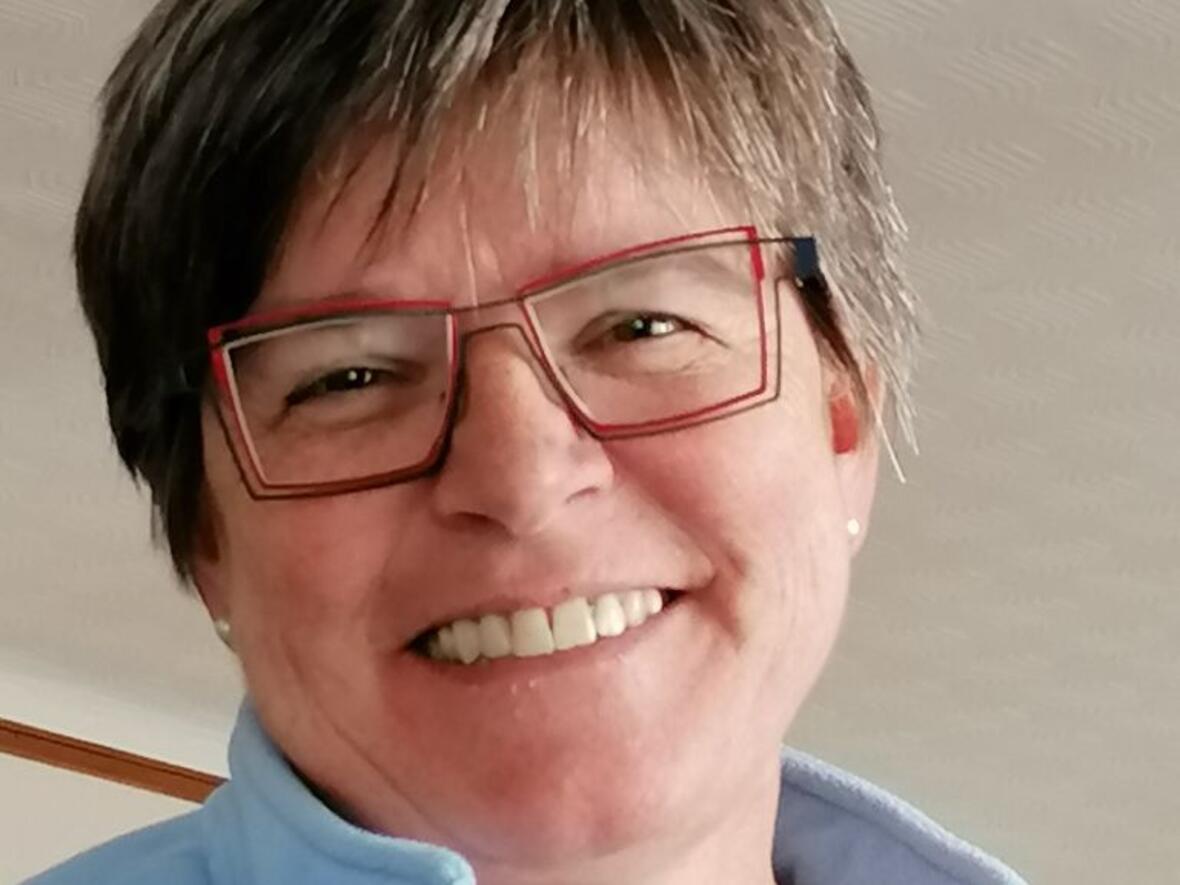 Eine lächelnde Frau mit Brille.