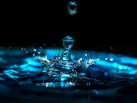 Ein Tropfen Wasser vor schwarzem Hintergrund 