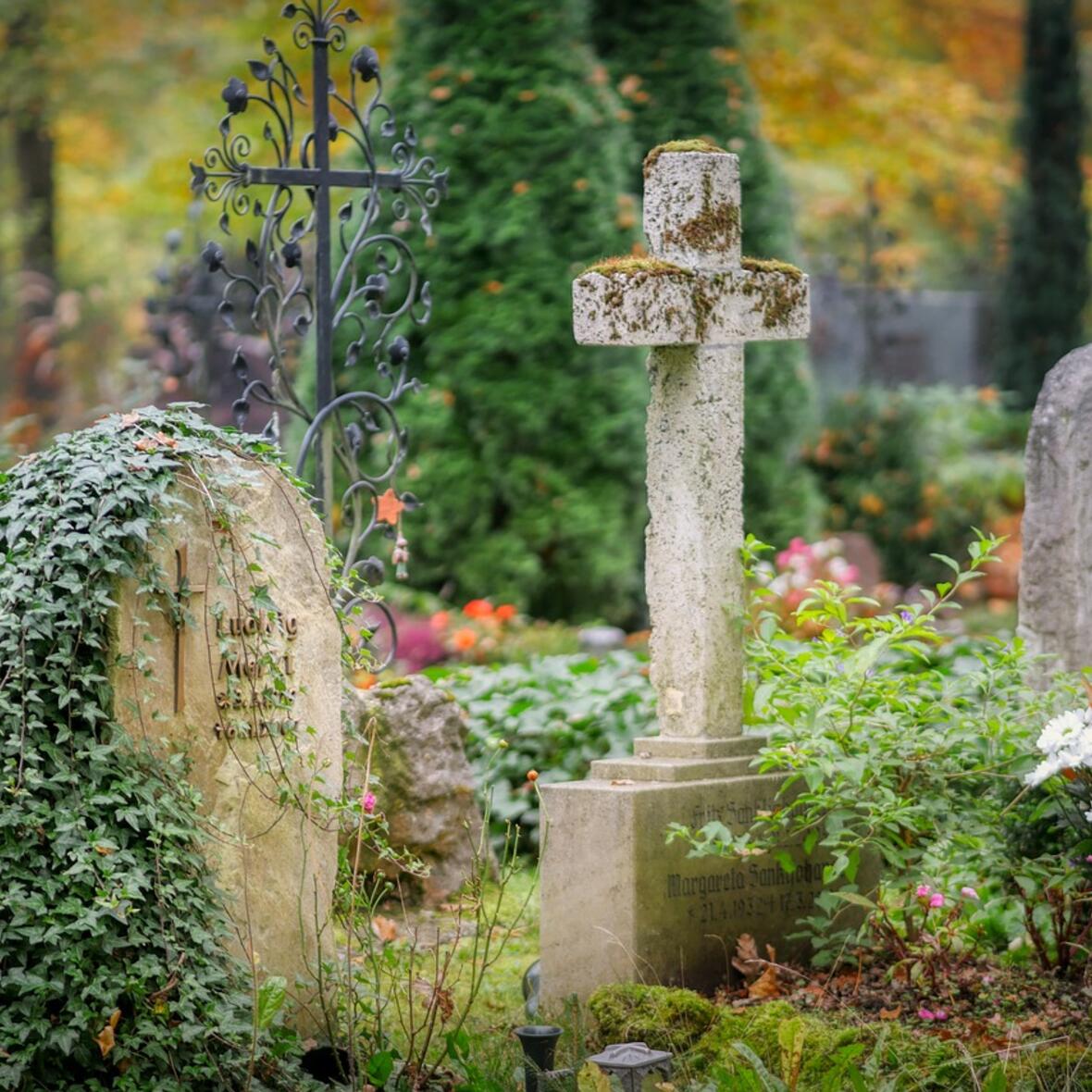 Ein parkähnlicher Friedhof mit Grabsteinen. 