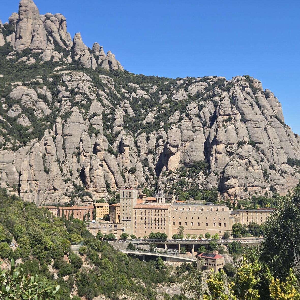 Der Gebäudekomplex der Klosteranlage Montserrat, der sich am Fuße einer  Felsformation befindet.