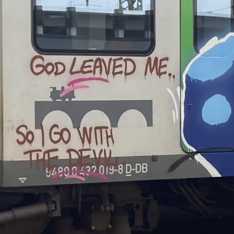 Auf der Außenseite eines Zugwagens ist ein Graffiti mit dem englischen Schriftzug „God left me, so I go with the devil“ („Gott hat mich verlassen, also gehe ich mit dem Teufel“) zu sehen. Der Zug ist teilweise mit weiteren bunten Graffiti gestaltet.