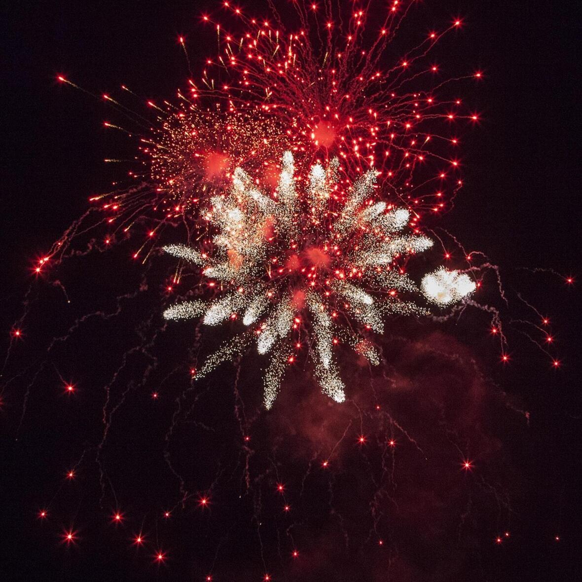 Feuerwerk in roter und weißer Farbe am Nachthimmel