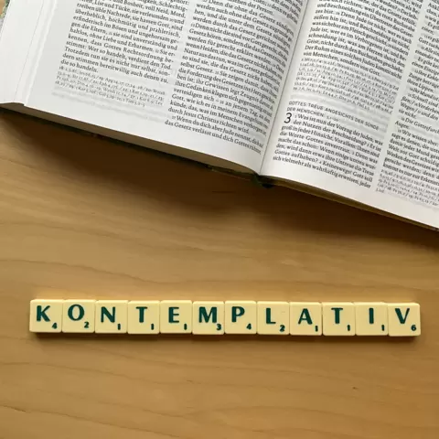 Unterhalb einer Bibel ist mit Scrabble Steinen das Wort: "Kontemplation" gelegt