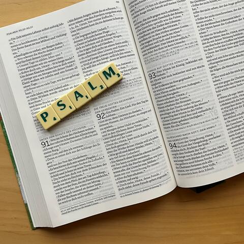 Unterhalb einer Bibel ist mit Scrabble Steinen das Wort: "Psalm" gelegt