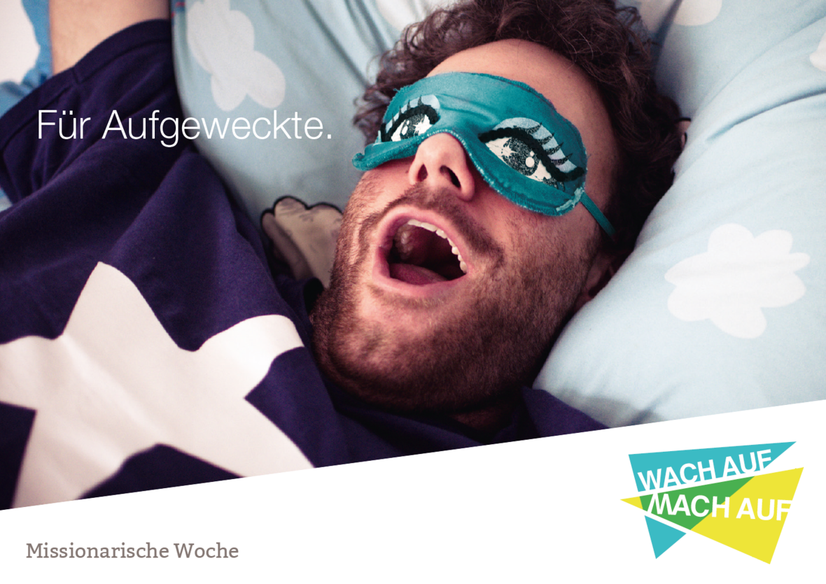 Ein Mann mit Schlafmaske liegt im Bett und gähnt.