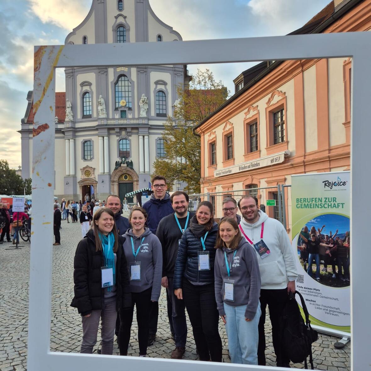 Auf einem Bilderrahmen steht das Wort Hoffnungsträger. Im Rahmen sind junge Menschen vor der Basilika St. Anna in Altötting zu sehen. 
