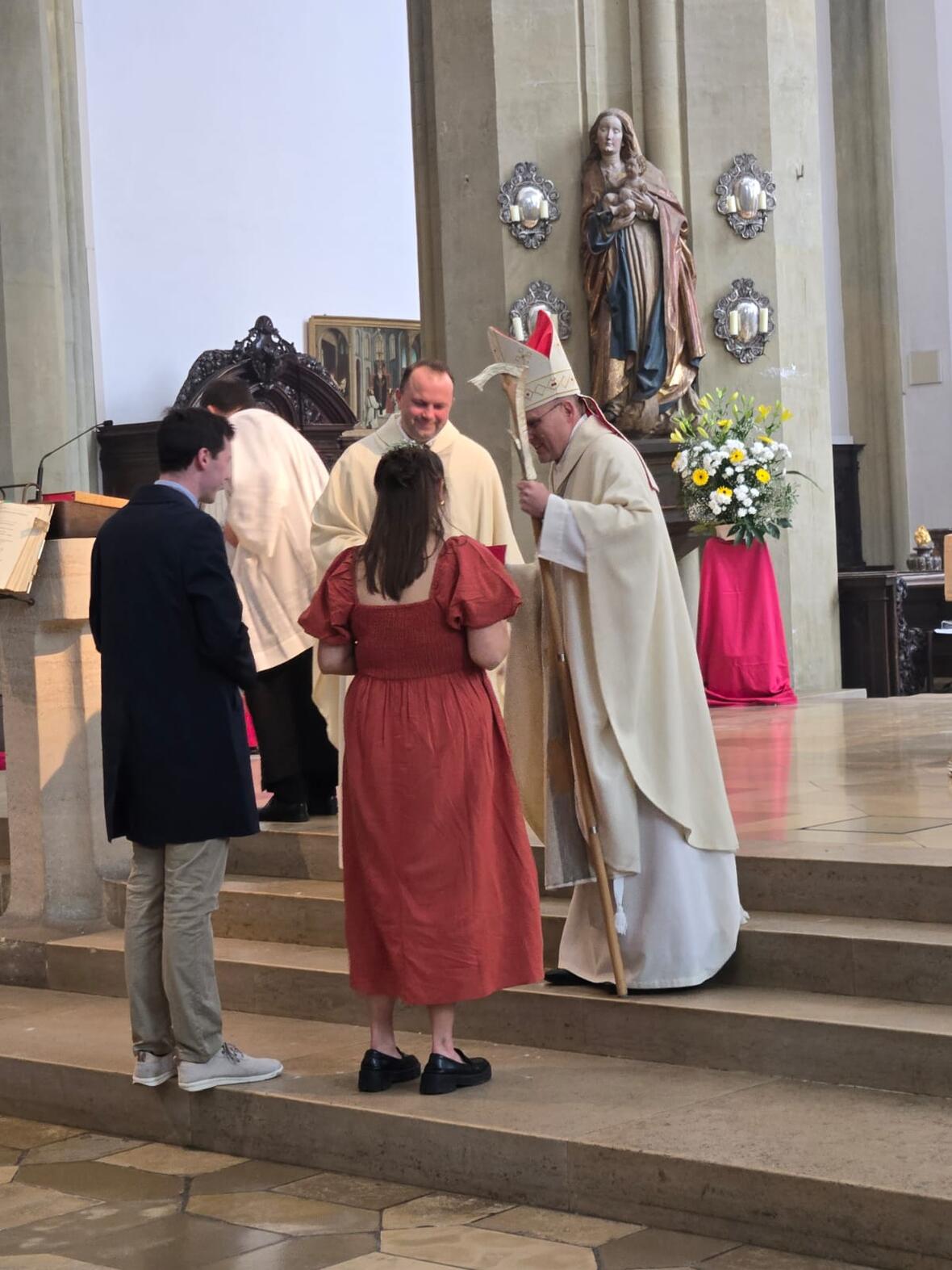 Eine junge Frau wird im Altarraum von St. Ulrich und Afra durch Weihbischof Florian Wörner gefirmt. 