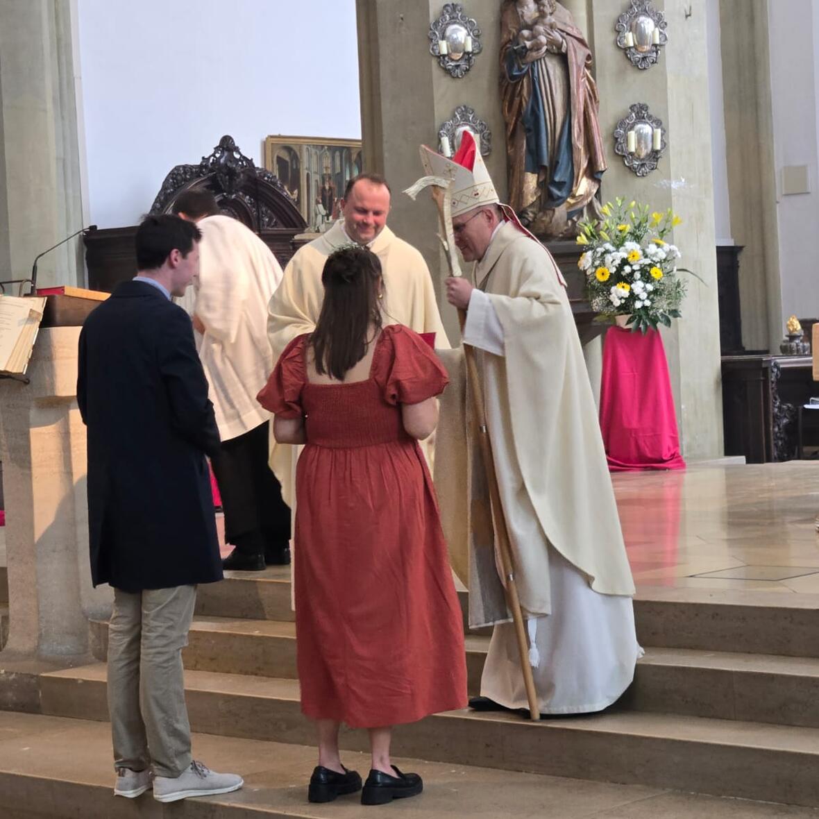 Eine junge Frau wird im Altarraum von St. Ulrich und Afra durch Weihbischof Florian Wörner gefirmt. 
