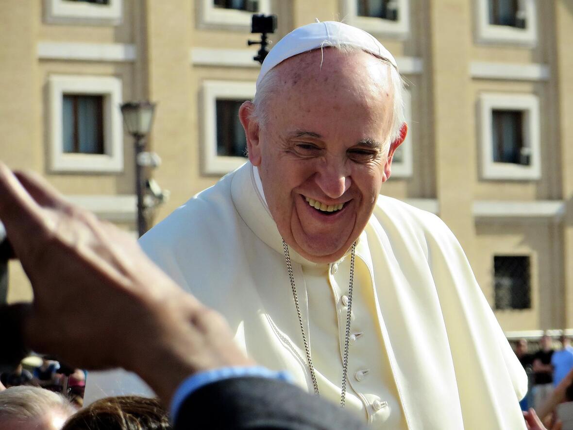 Papst Franziskus lächelt der Menschenmenge bei einer Generalaudienz zu