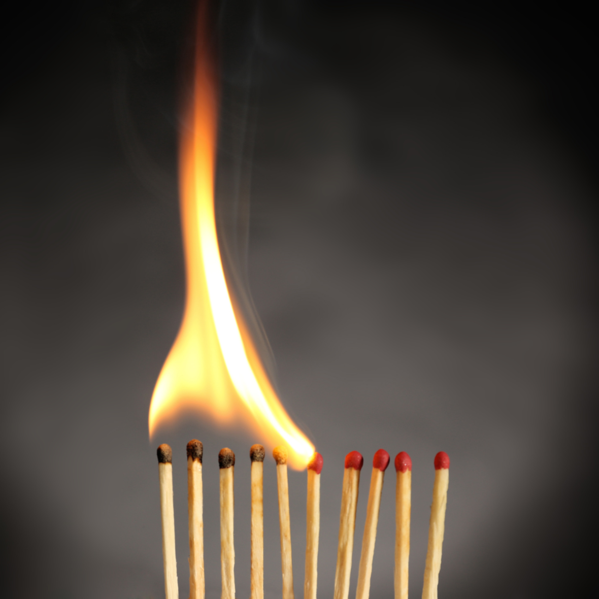 Die Flamme breitet sich über mehrere Streichhölzer aus. 