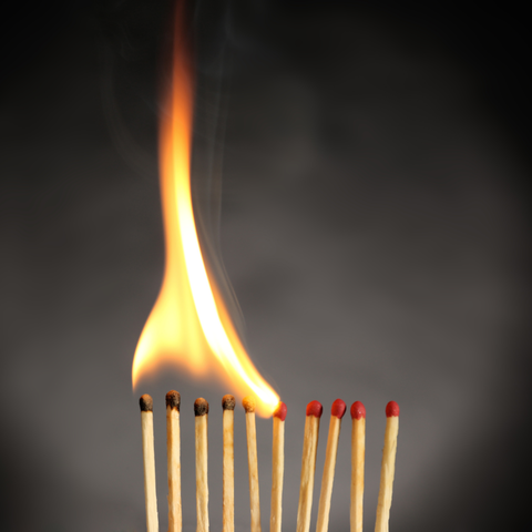 Die Flamme breitet sich über mehrere Streichhölzer aus. 