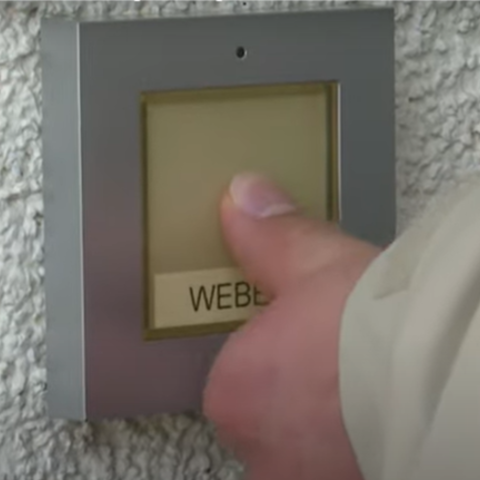 Eine Hand betätigt eine Klingel.