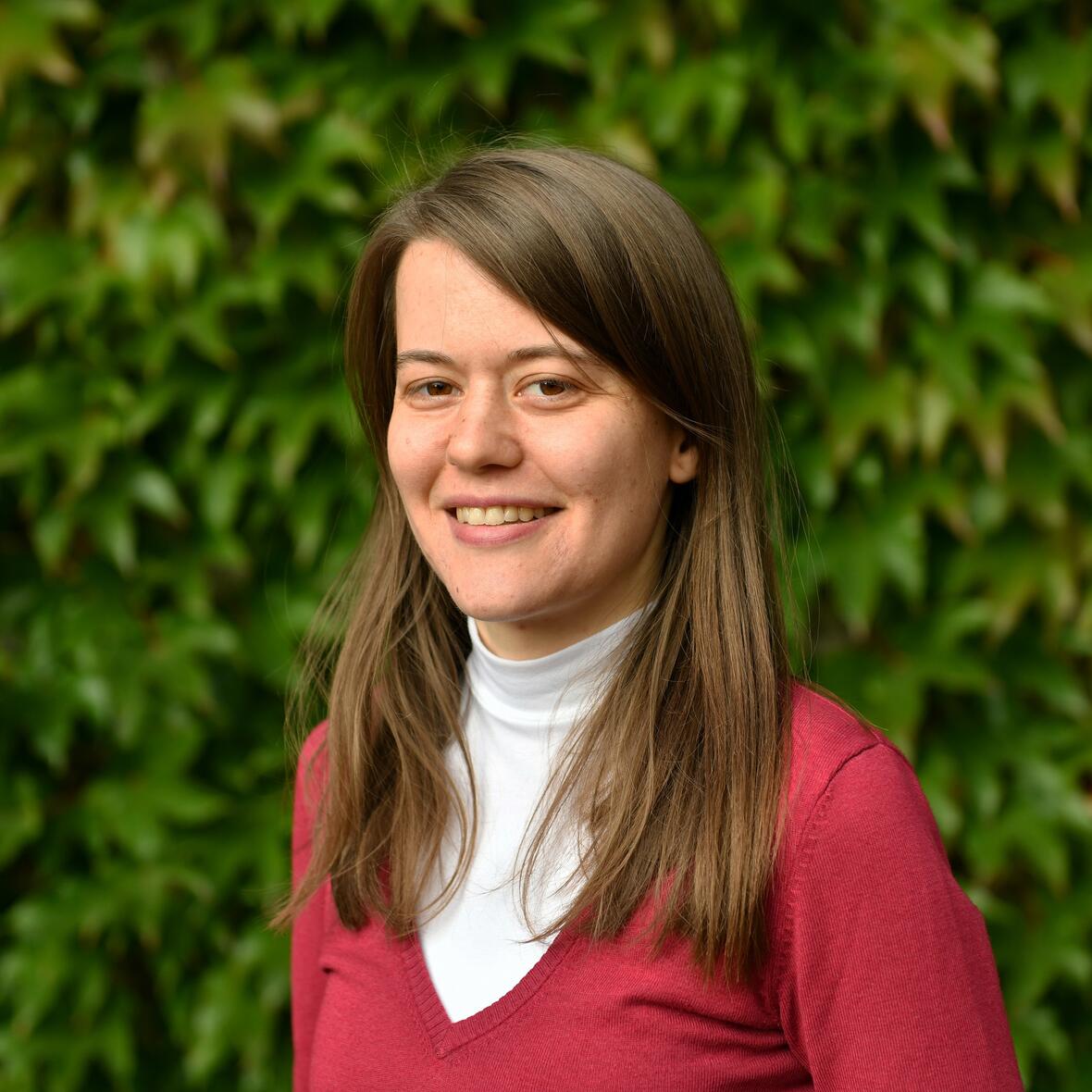 Katharina Weiß vor einer Wand mit Efeu 