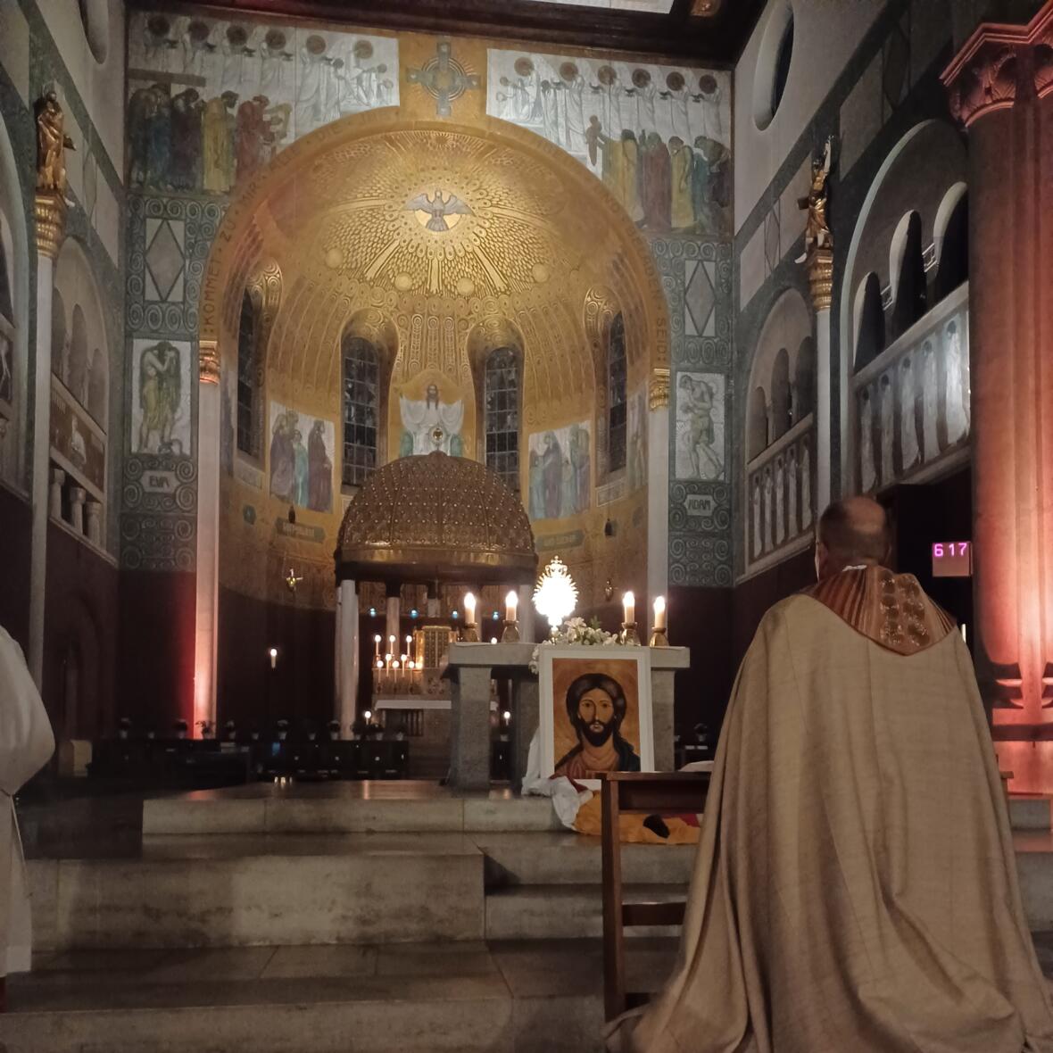 Gebetswache 2025 Weihbischof Wörner kniet in der Herz Jesu Kirche Augsburg Pfersee betend vor dem Allerheiligsten. Vor dem Altar steht eine große Jesusikone.