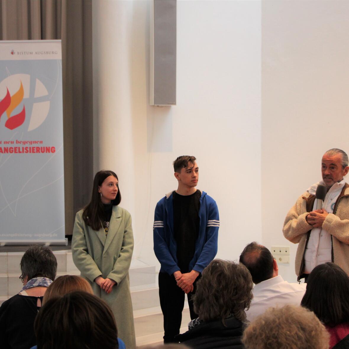 Zwei Jugendliche und Pater Alois berichten vor dem Plenum von ihren Erfahrungen mit Jugendalphakursen