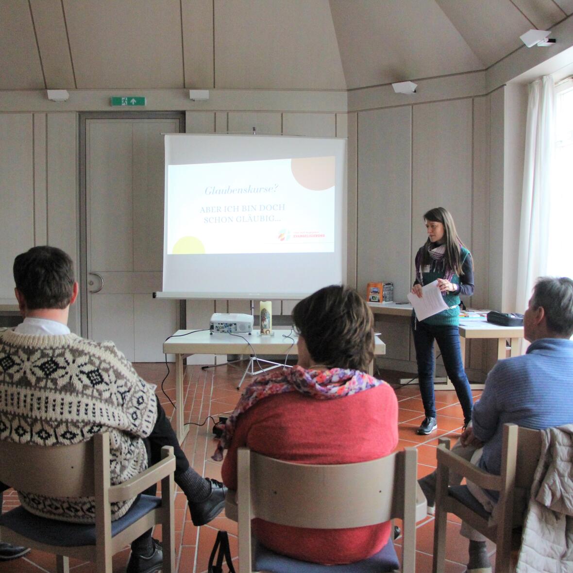 Eine Referentin spricht vor einer kleinen Gruppe von Menschen über Glaubenskurse